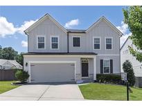 Charming two-story home with a gray exterior, well-maintained lawn, and a two-car garage on a sunny day at 522 Evans Ln, Woodstock, GA 30188