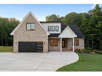 Beautiful exterior view of modern home with brick, black trim and a driveway at 863 N Bay Overlook, Villa Rica, GA 30180