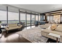 Bright living room featuring hardwood floors, a modern sofa, and floor-to-ceiling windows with a stunning city view at 3344 Peachtree Ne Rd # 3405, Atlanta, GA 30326