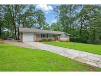Charming single-story home with a well-maintained front yard, driveway, and attached garage at 1960 Oak Leaf Sw Ct, Marietta, GA 30008