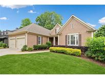 Charming one-story home featuring manicured lawn and beautiful landscaping at 6245 Hampton Golf Club Dr, Cumming, GA 30041