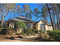 Charming one-story home featuring a well-manicured front yard with mature trees and tasteful landscaping at 120 Bent Creek Dr, Woodstock, GA 30189