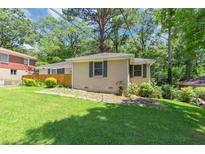 Ranch-style home with a well-maintained lawn and mature trees providing shade and curb appeal at 2702 Rollingwood Se Ln, Atlanta, GA 30316