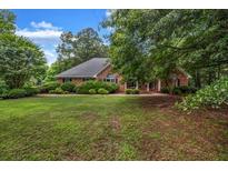 Charming single-story brick home surrounded by lush landscaping and a sprawling lawn at 362 Clyde Ct, Mcdonough, GA 30252