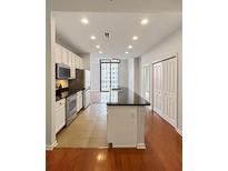 Modern kitchen features white cabinets, stainless steel appliances, and a large island with dark countertops at 3040 Peachtree Nw Rd # 1501, Atlanta, GA 30305