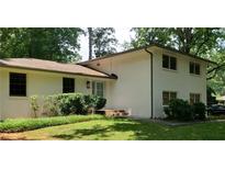 Charming, traditional-style two-story home with white brick, well-maintained landscaping, and mature trees at 4485 Lake Ivanhoe Dr, Tucker, GA 30084