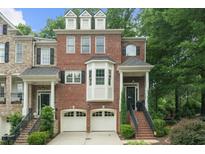 Charming brick townhome with a two-car garage and manicured landscaping at 5968 Reddington Way, Sandy Springs, GA 30328