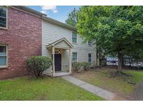 Charming home with a brick accent wall, light siding, well-manicured bushes, and a sidewalk leading to the front door at 1707 Taylor Ave, Atlanta, GA 30344