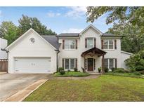 Charming two-story home featuring a lush front yard, white brick facade, and inviting entryway at 2205 Waters Ferry Dr, Lawrenceville, GA 30043