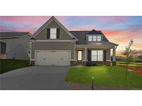Charming craftsman-style home with a manicured lawn and two-car garage under a colorful sunset sky at 49 Masters Dr, Villa Rica, GA 30180