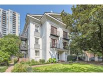Charming white three-story home featuring private balconies, lush landscaping and manicured lawn at 1078 Piedmont Ne Ave # 206, Atlanta, GA 30309