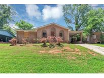 Charming brick home featuring a covered front porch and carport, complemented by a lush green lawn and mature trees at 5267 Sheppard Ln, Stone Mountain, GA 30083