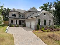 Charming two-story home with brick facade, three car garage, and a paved driveway at 912 Sunny Meadows Ln, Marietta, GA 30062
