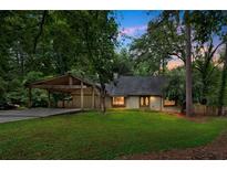 Charming home with a spacious yard, carport, and inviting front entrance surrounded by trees at 112 Valley Rd, Stockbridge, GA 30281