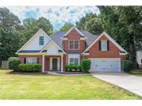Charming two-story brick home with a well-manicured lawn and lush landscaping, creating inviting curb appeal at 1245 Grace Hadaway Ln, Lawrenceville, GA 30043