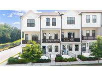 Beautiful townhome exterior with white siding, black trim, private balconies and landscaping at 1247 Zucchini Se Cir, Atlanta, GA 30315