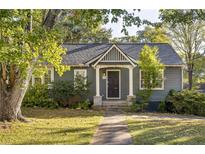 Charming home with a well-maintained lawn, mature trees and inviting front porch and gray siding at 954 Bouldercrest Se Dr, Atlanta, GA 30316