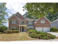 Charming two-story brick home featuring a manicured front yard and attached two-car garage at 250 Lawrence Pl, Atlanta, GA 30349