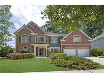Charming two-story brick home with a well-manicured lawn and lush landscaping at 250 Lawrence Pl, Atlanta, GA 30349