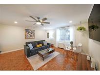 Bright living room featuring hardwood floors, comfortable seating, and modern ceiling fan for added comfort at 300 Peachtree Ne St # 14H, Atlanta, GA 30308