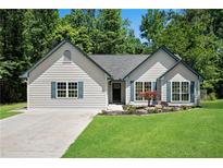 Charming single-story home featuring a well-manicured lawn, blue shutters, and a welcoming entrance at 8592 Hidden Creek Cir, Snellville, GA 30039