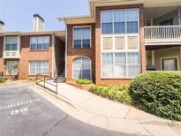 Brick condo building exterior featuring a reserved parking spot and well-maintained landscaping at 200 Renaissance Ne Pkwy # 310, Atlanta, GA 30308