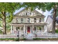 Charming two-story home with a classic white picket fence and inviting front porch nestled among mature trees at 2092 Wood Nw Trl, Atlanta, GA 30318