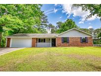 Charming brick home with manicured lawn, attached garage, and inviting front porch at 2931 Randolph Ct, Conyers, GA 30012