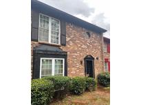 Charming brick townhome with black shutters and a well-maintained front yard offers classic curb appeal at 658 Garden Walk Dr, Stone Mountain, GA 30083