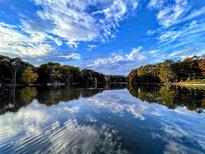 Scenic lake view reflecting blue sky with clouds, surrounded by lush trees at 696 Kenilworth Cir, Stone Mountain, GA 30083