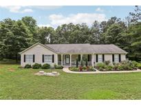 Charming ranch-style home with a welcoming front porch and well-manicured lawn and landscaped garden at 105 Laney Ct, Mcdonough, GA 30252