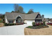 Charming single-story home featuring a lush, landscaped front yard and an attached two-car garage at 15 Azalea Lakes Ct, Dallas, GA 30157