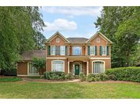 Charming two-story home with well-manicured lawn and mature trees, featuring green shutters and a covered entryway at 170 Glen Eagle Way, Mcdonough, GA 30253