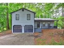 Charming two-story home with a 2-car garage and inviting front porch nestled amongst mature trees at 129 Lester Nw Rd, Lawrenceville, GA 30044