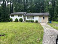 Split level home showcasing a well-maintained lawn and partial driveway at 1681 Sw Hammond Woods Sw Cir, Marietta, GA 30008