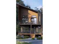 Modern two-story home with wood and dark siding, black framed windows, and a double deck with metal railings at 4354 River Rd, Ellenwood, GA 30294