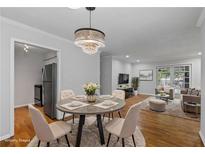 Bright open-concept living and dining area with a modern chandelier and hardwood flooring at 1150 Collier Nw Rd # 6H, Atlanta, GA 30318