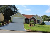 Charming single-story home features a lush lawn and well-maintained landscaping, complemented by a paved driveway at 5574 Mccrossin Cir, Lithonia, GA 30038