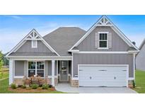 Charming one-story home with a two-car garage, stone accents, and a cozy front porch with seating at 18 Torry Pines Cir, Villa Rica, GA 30180