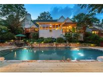 Stunning backyard pool with stone accents, lush landscaping, and deck perfect for outdoor entertaining at 4820 Coppedge Trl, Duluth, GA 30096