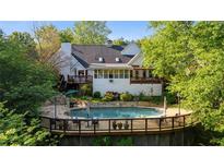 A pristine pool with a surrounding deck enhances the backyard of this stylish white home at 4820 Coppedge Trl, Peachtree Corners, GA 30096