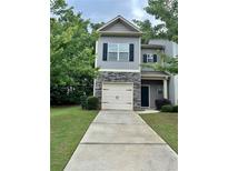Two-story home with stone accents, a driveway, and a well-manicured lawn at 664 Oakside Pl, Acworth, GA 30102