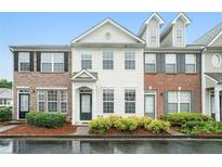 Beautiful townhouse with manicured landscaping, brick accents, and ample windows for natural light at 2709 Heathrow Dr, Lawrenceville, GA 30043