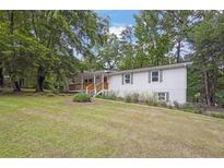 Charming home featuring a well-maintained lawn and inviting front porch with wooded surroundings at 5666 Fawn Dr, Powder Springs, GA 30127