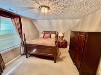 Comfortable bedroom featuring a bed and matching dark wood dresser and a textured ceiling at 230 White Rd, Fayetteville, GA 30214
