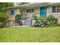 Charming home featuring a bright blue door and shutters, with a well-maintained landscaped front yard at 4611 Dogwood Rd, Pine Lake, GA 30072