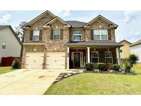 Beautiful brick home with a well-manicured lawn and a two-car garage at 558 Hideaway Dr, Jonesboro, GA 30238
