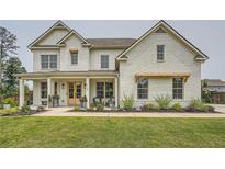 Charming white brick home with well-manicured lawn, covered front porch, and double doors at 6168 Sweet Birch Ct, Acworth, GA 30101