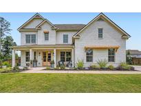 Beautiful two-story home with a charming brick exterior, covered porch and manicured landscaping at 6168 Sweet Birch Ct, Acworth, GA 30101