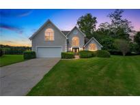 Charming home featuring a manicured lawn, double-door entrance, and an attached two-car garage at 164 Gleneagles Way, Fayetteville, GA 30215